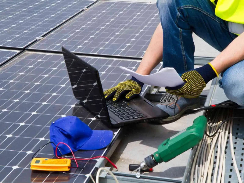 Dieses Bild zeigt einen Mitarbeiter, der gerade eine Wartung an einem Solarmodul vornimmt.